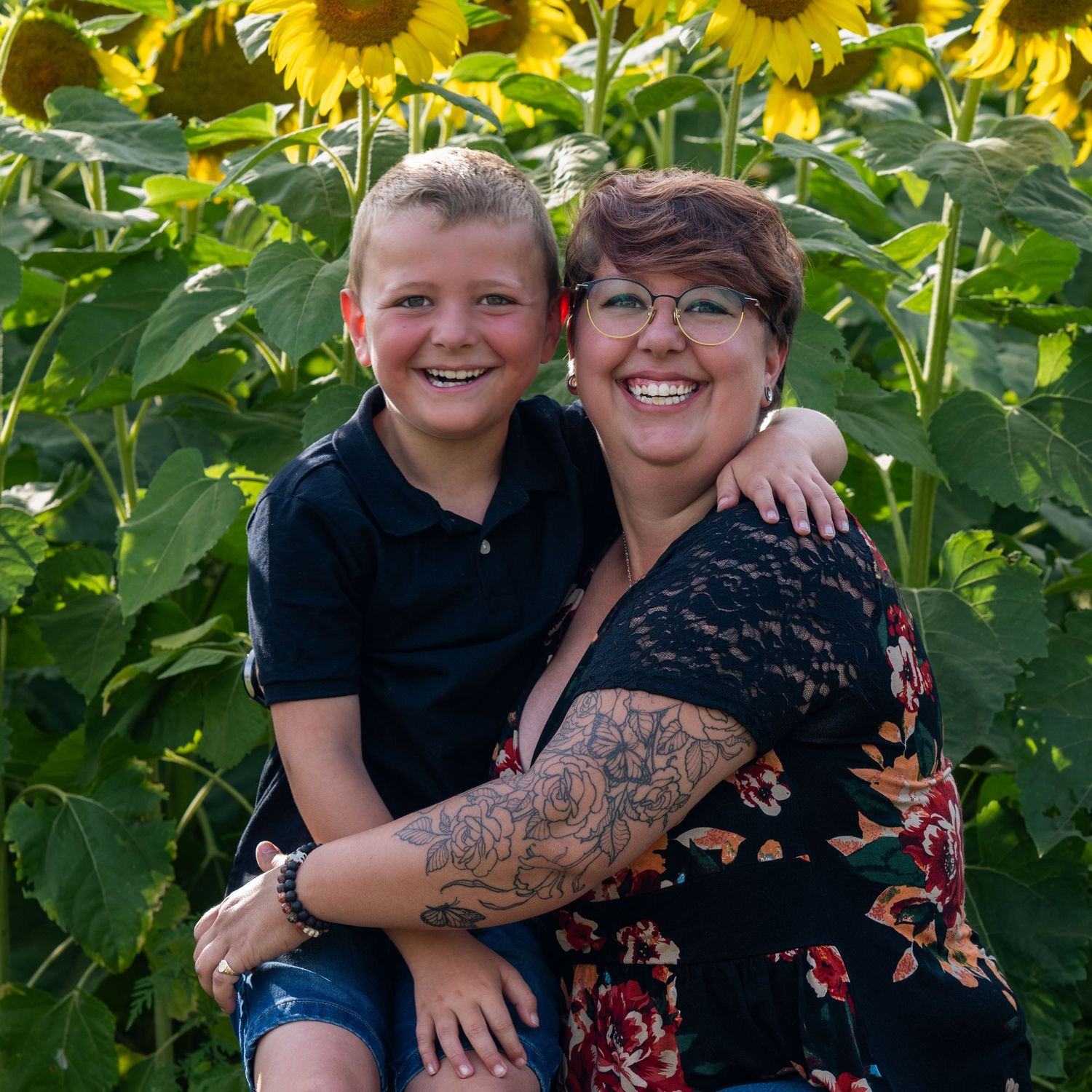 Mother and son smile in New Hampshire Sunflower field for family Sunflower Mini Session portrait