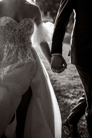 Black and white detail shots of a wedding dress and couple's hands creating an artistic silhouette effect.
