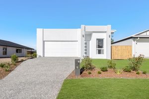 Modern white two-story home with gravel driveway, manicured lawn, and minimalist landscaping under a clear blue sky.