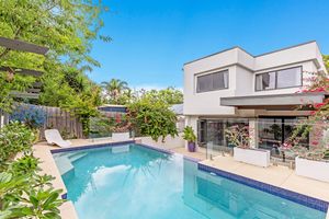Contemporary two-storey home with large swimming pool, tropical plants, and outdoor entertaining area.