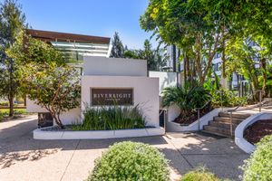 Riverlight apartment complex entrance with elegant white rendered walls and tropical landscaping.