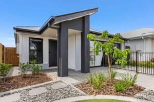 Contemporary dark-accented single-storey home with landscaped garden and paved pathway.