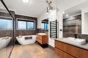 Luxurious master bathroom with freestanding soaking tub, dual vanities, and heated towel rail.
