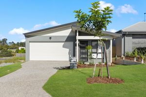 Modern single-storey home with white garage door, rendered facade, and neat landscaped front yard.