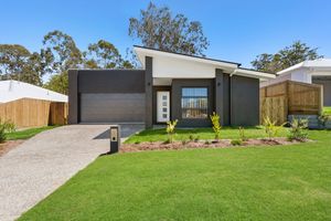 Contemporary single-storey home with dark accents, double garage, and manicured lawn.