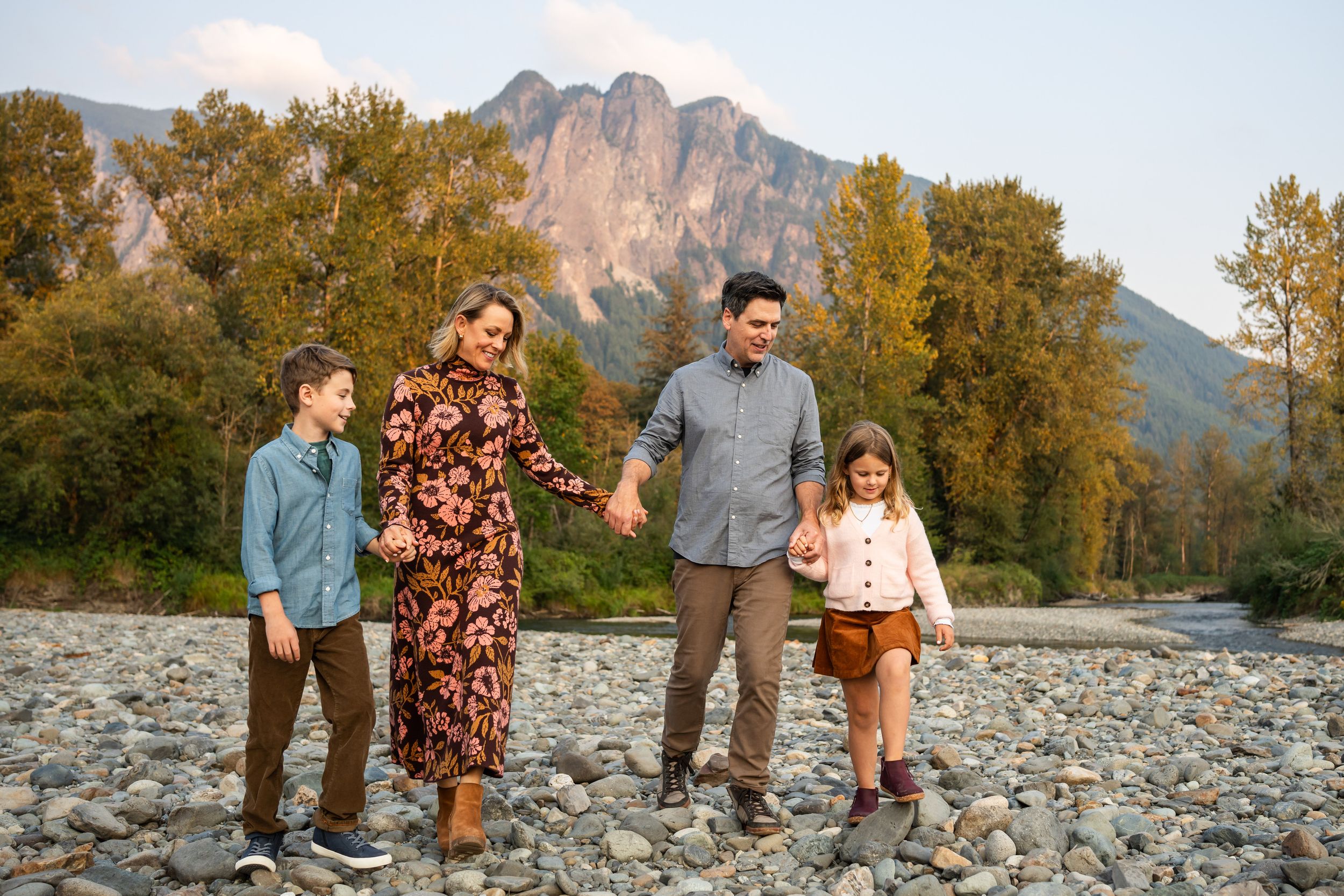 Family walking through the rocky riverbed with Mt. Si in the background.