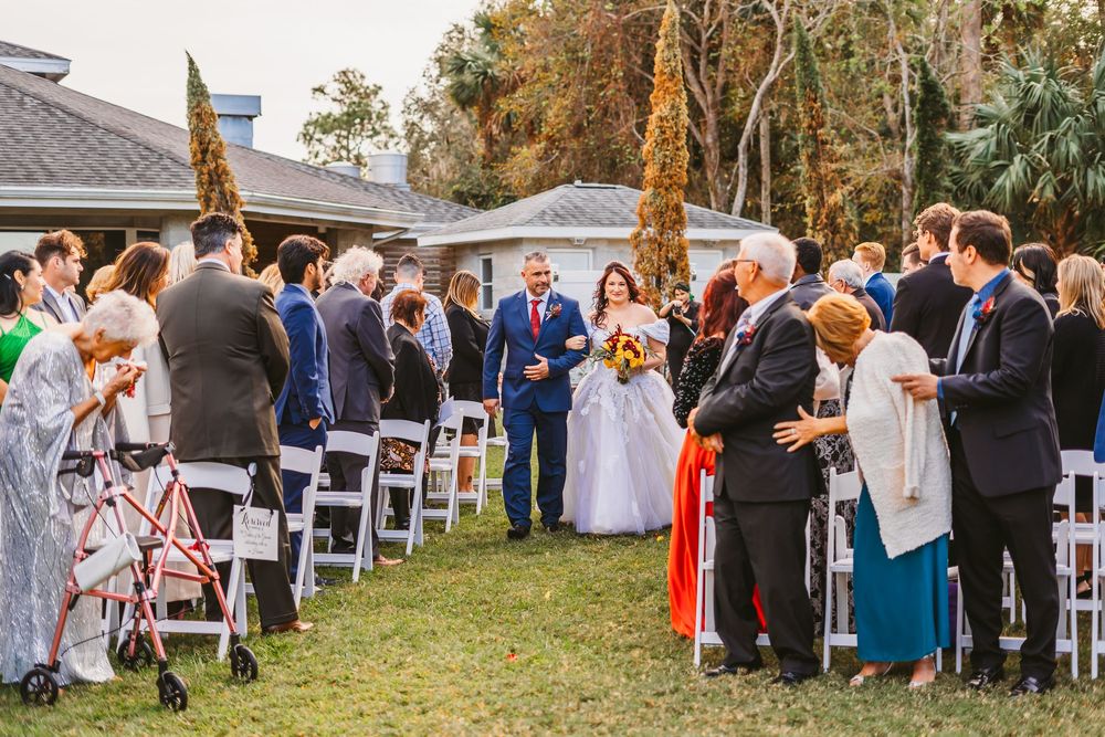 Channel Side Club in Palm Coast Florida. Wedding photography of outdoor ceremony. Bride wears princess gown while walking down aisle.