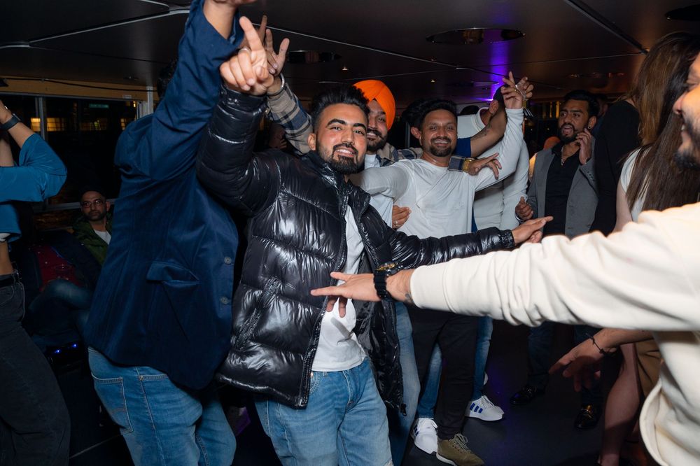 People dancing and celebrating at a lively indoor party event with guests enjoying the festivities.