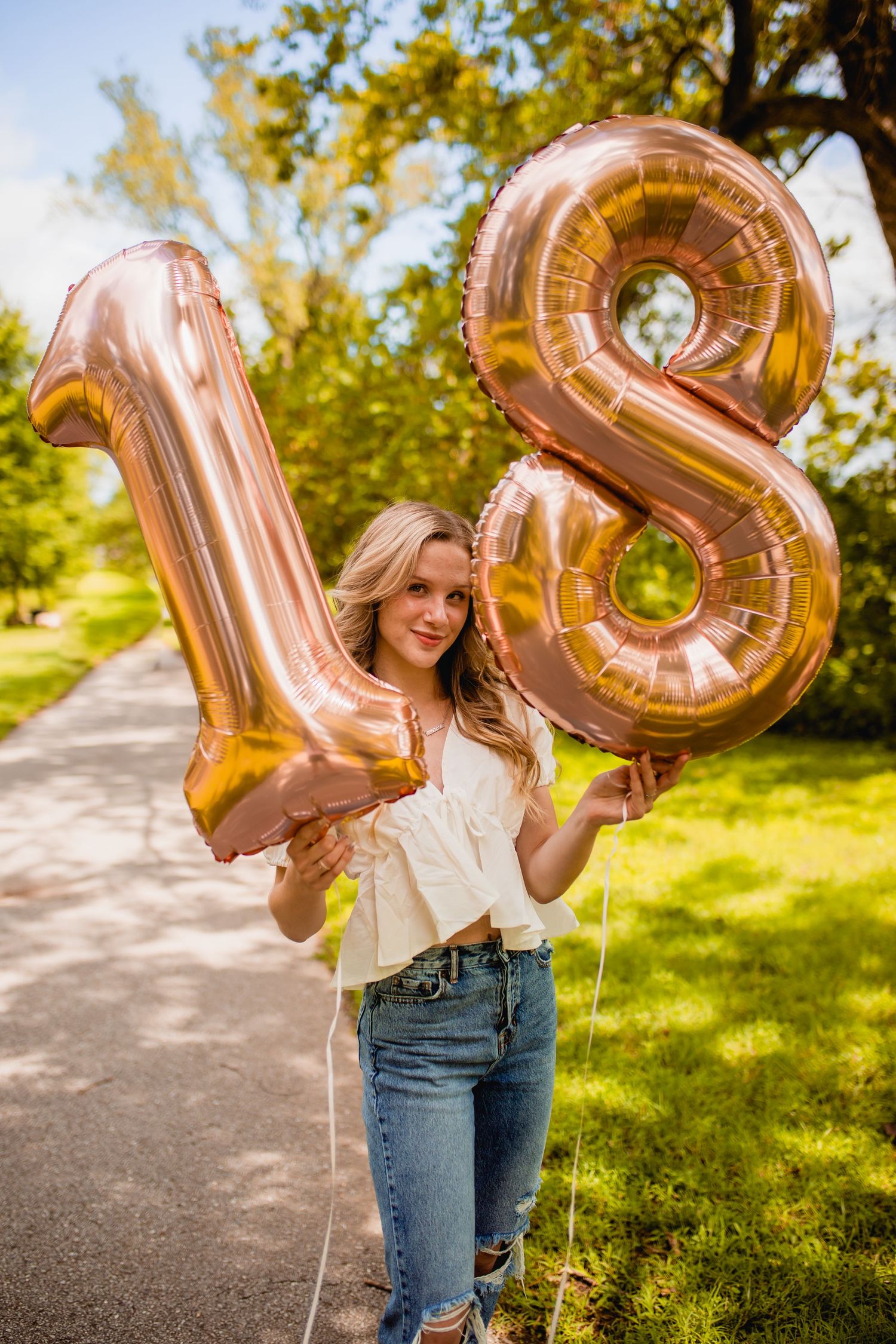 senior girl with 18th birthday balloons posing for portrait by morgan lea photography in branson missouri