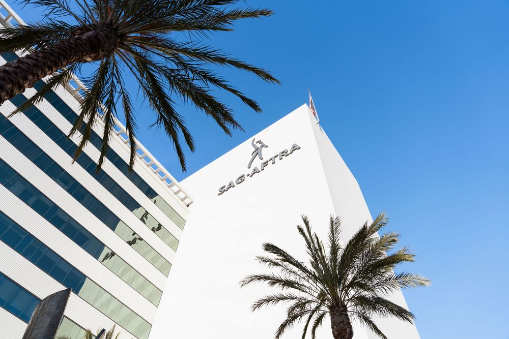 SAG-AFTRA headquarters building exterior with palm trees against a clear blue sky in Los Angeles.