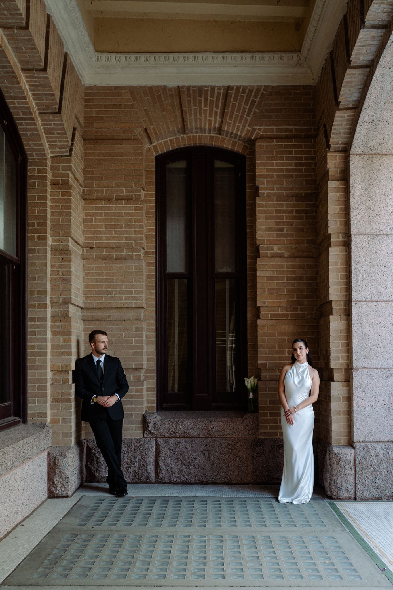 Bride and groom posed under the corridor of the historic 1910 Harris County Courthouse.