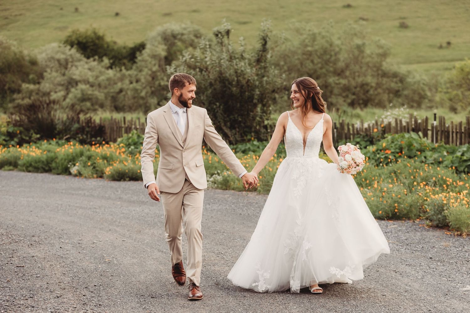 Bride and groom sharing a kiss between ornate wrought iron gates, bride holding white bouquet in elegant wedding attire.