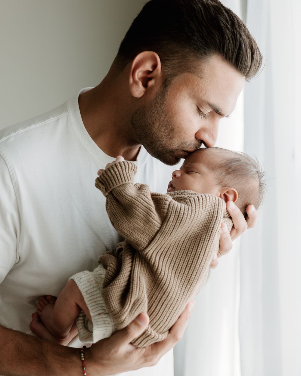 Beautiful Dad and baby using natural window light during in-home newborn session in East Tx Motherhood Photography