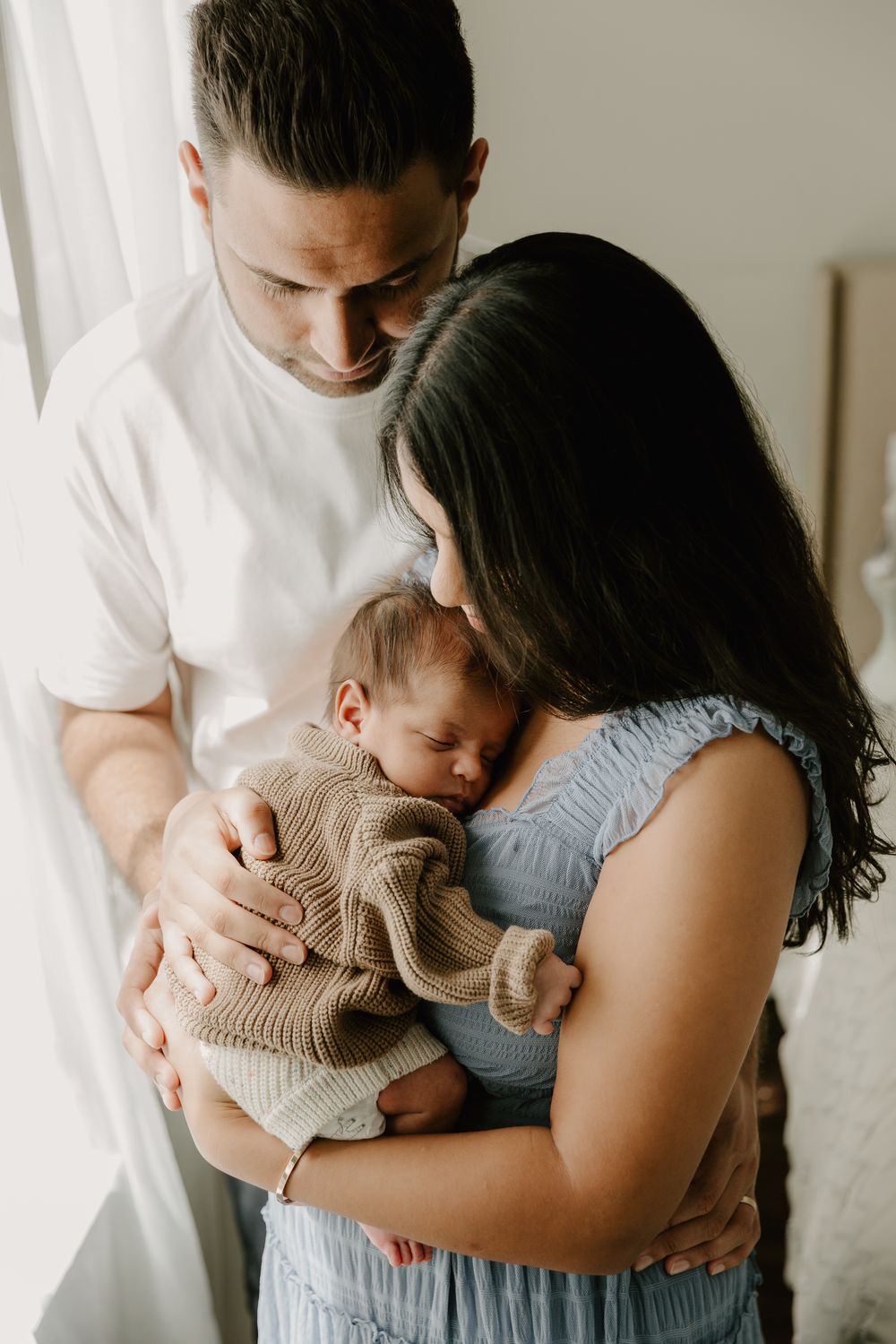 Natural light photographer capturing family during in-home newborn photography session in East Texas