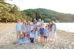 Large extended family portrait with grandparents and grandchildren on a sunny sandy beach. Ellacoya State Park, Gilford NH.