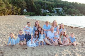 Large family group portrait on sandy beach at golden hour with lake behind. Ellacoya State Park, Gilford NH.