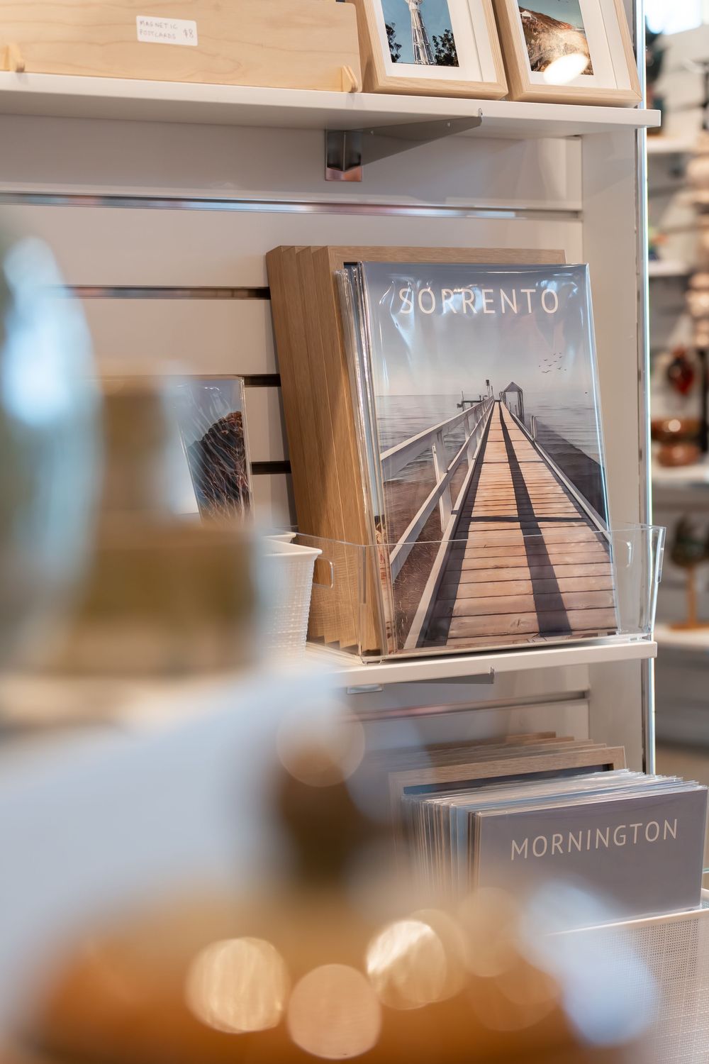 Sorrento and Mornington photo books displayed on a retail shelf in a gift shop.