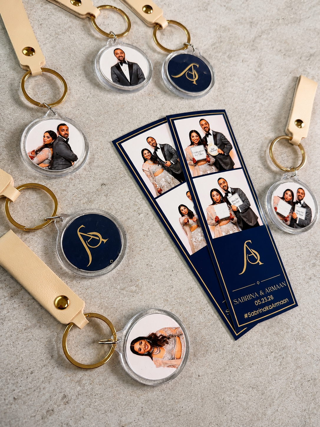 Wedding photo booth keychains and photo strips featuring a couple in navy and gold, personalized with monogram and hashtag.