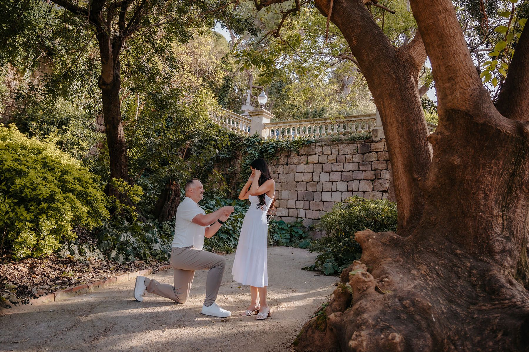 Candid engagement photoshoot in a hidden corner shielded by the rushing Montjuic waterfall walls.