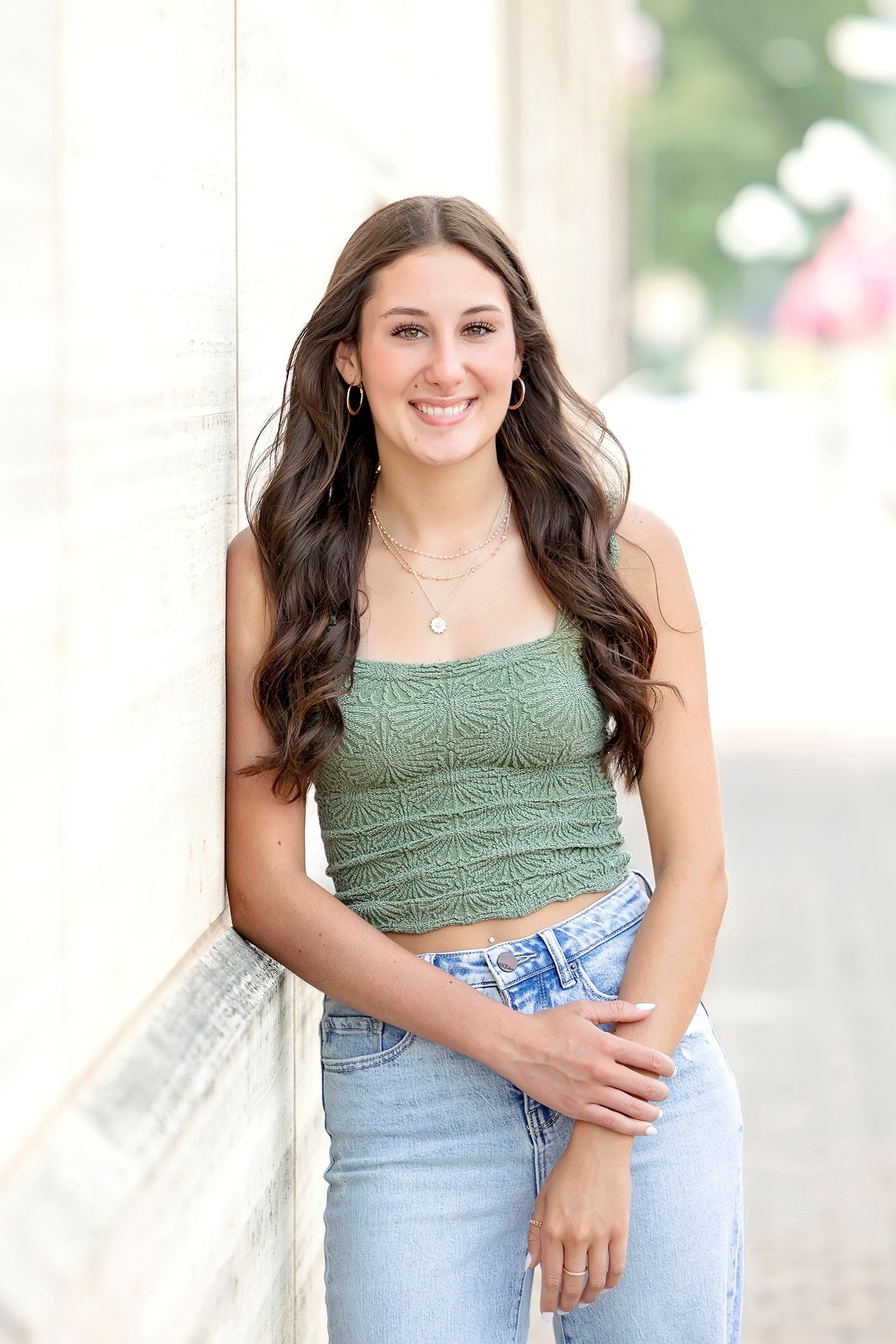 High school senior girl posing in a casual outfit downtown during a relaxed senior photography session in Clear Lake, Iowa.