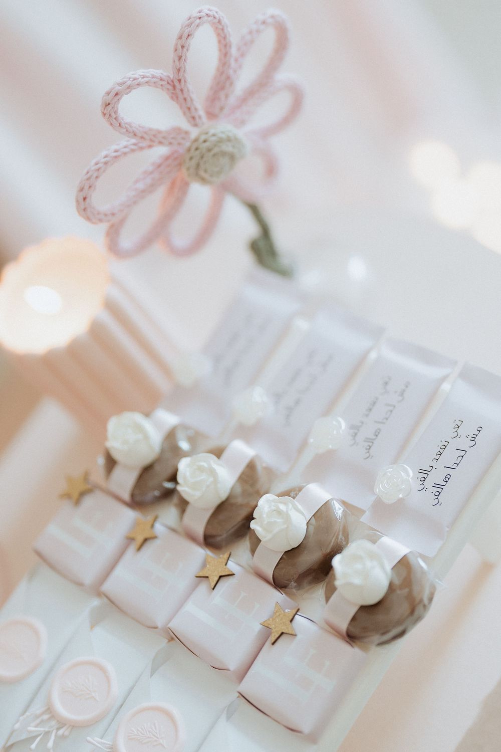 Decorated dessert table with wrapped favors and white rose accents at a baby celebration