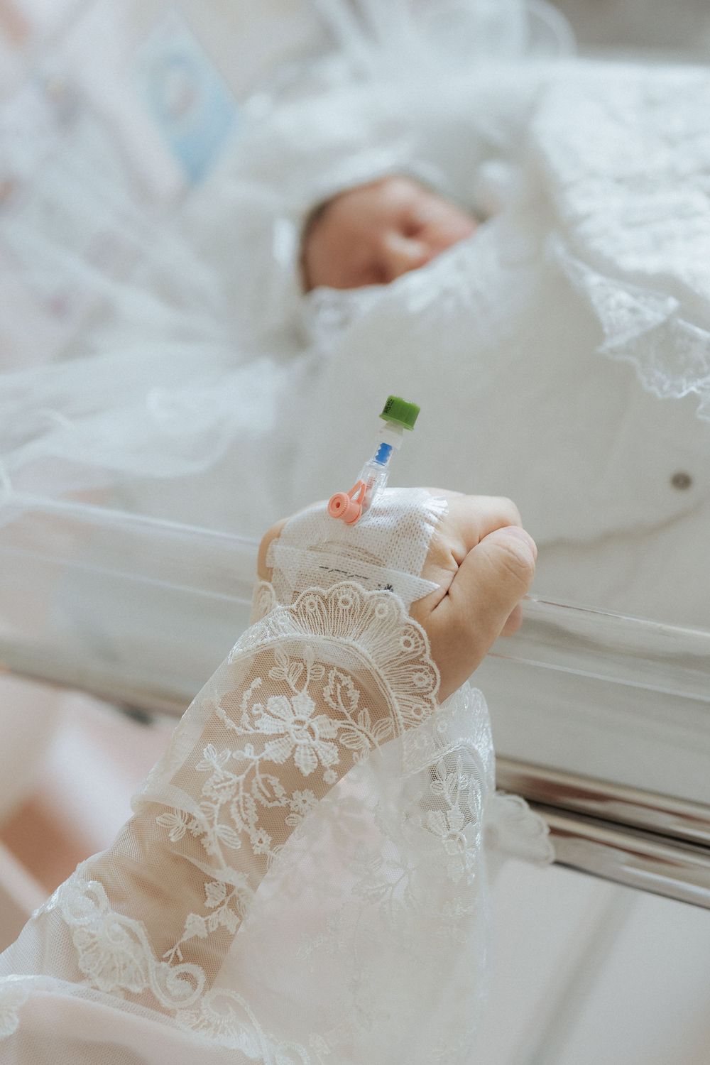 Newborn sleeping in a lace bassinet with a decorative name card at a baby photoshoot