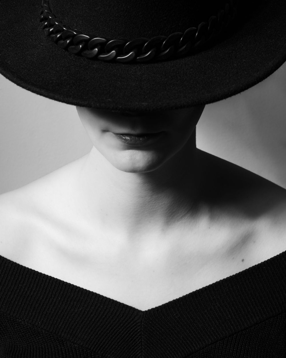 Portrait en noir et blanc mettant en scène une femme portant un chapeau à larges bords.