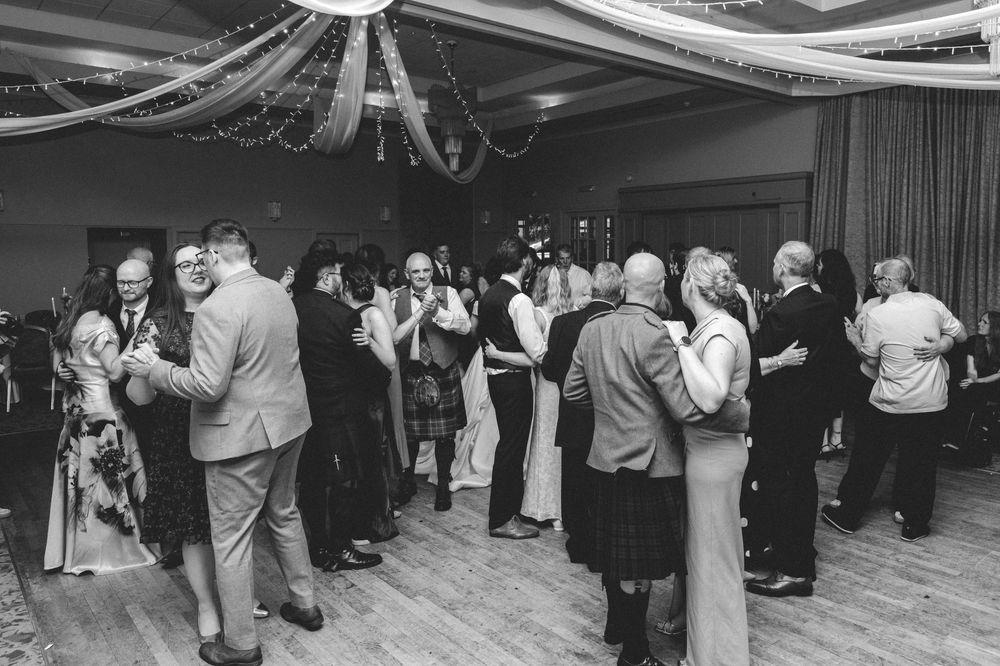 Guests dancing and celebrating on the dance floor at an elegant wedding reception.
