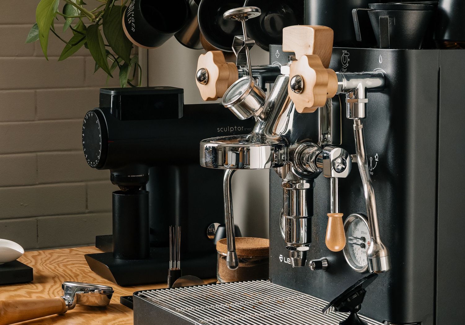 Villa Perk Coffee Co. branded paper cup with black sleeve and lid, surrounded by coffee beans on a wooden surface.