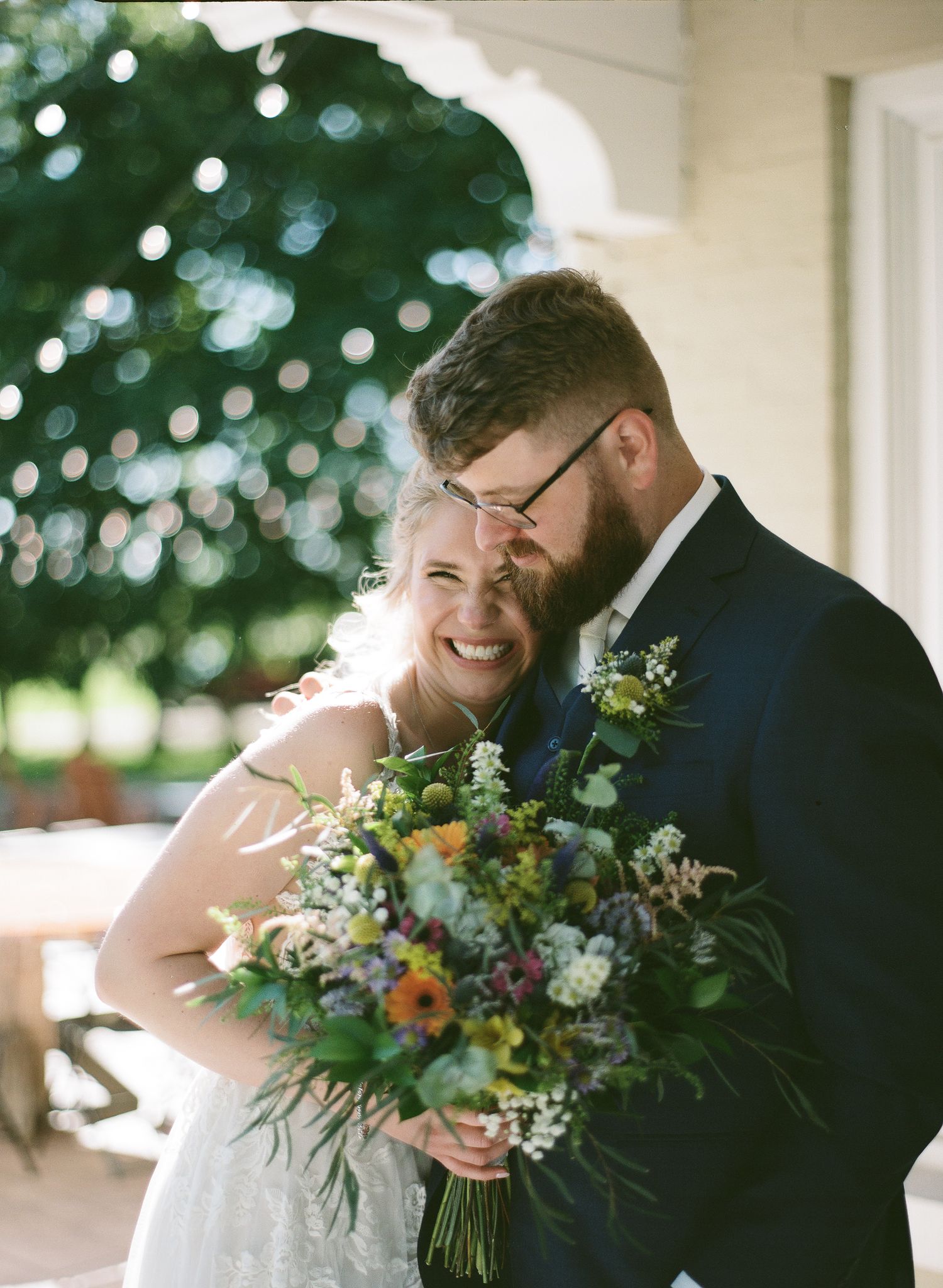 A romantic close up photo of a couple about to kiss at their wedding outdoors.