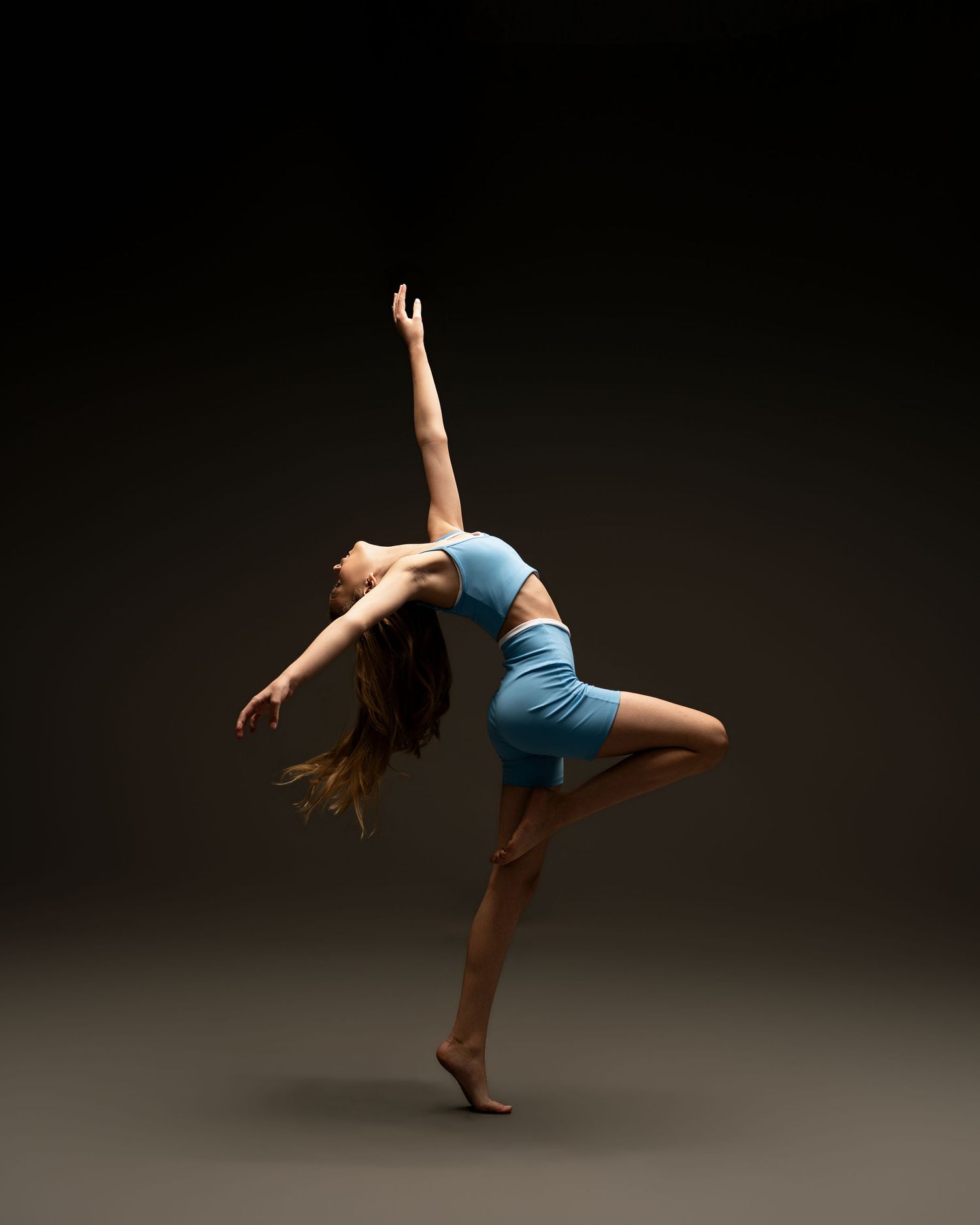 Young ballet dancer performing an elegant arabesque during a fine art portrait session. Dance photographer serving Northeast Florida