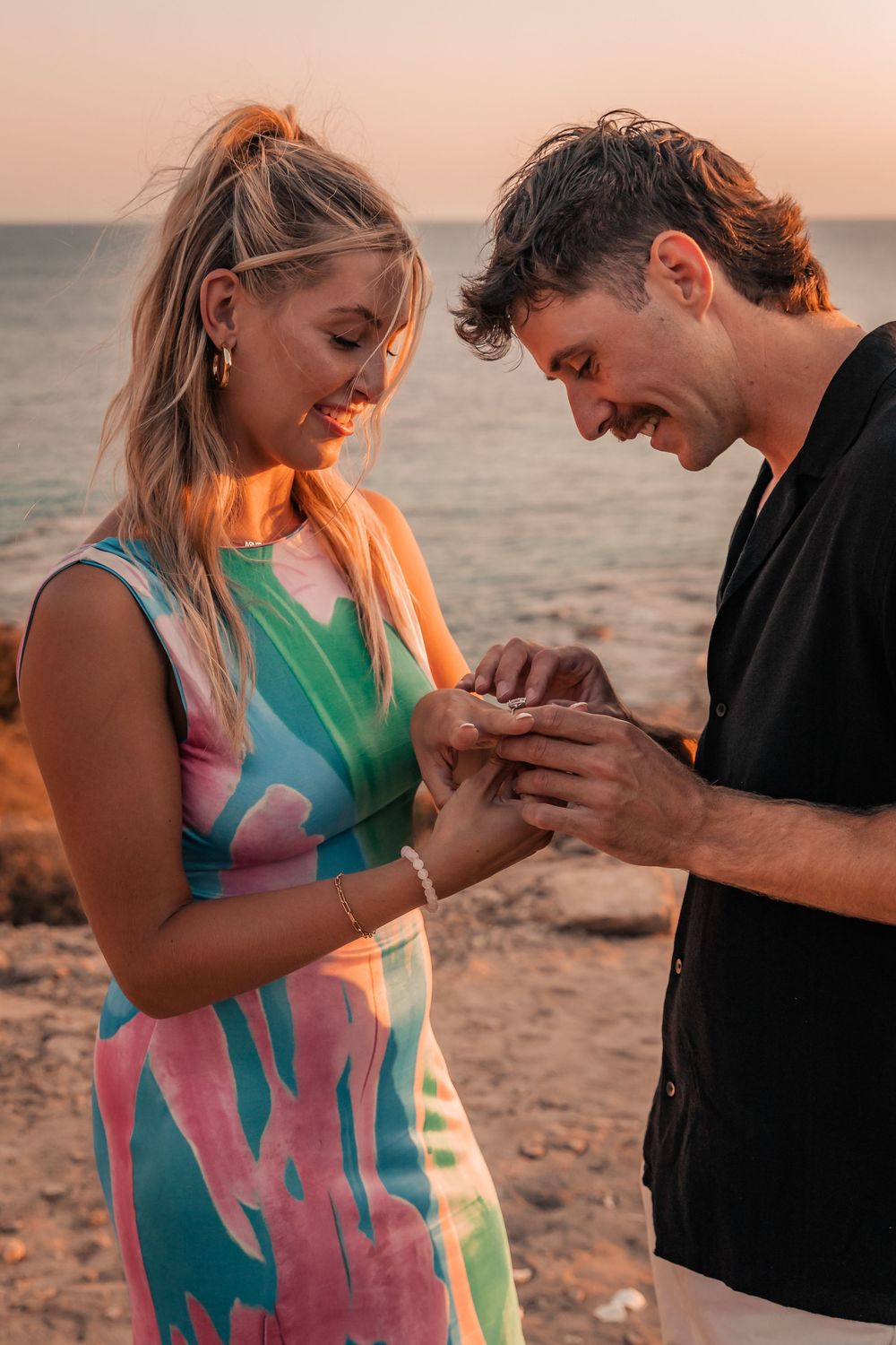 A close-up of a couple admiring her new engagement ring during a sunset surprise proposal photo session in Mallorca.