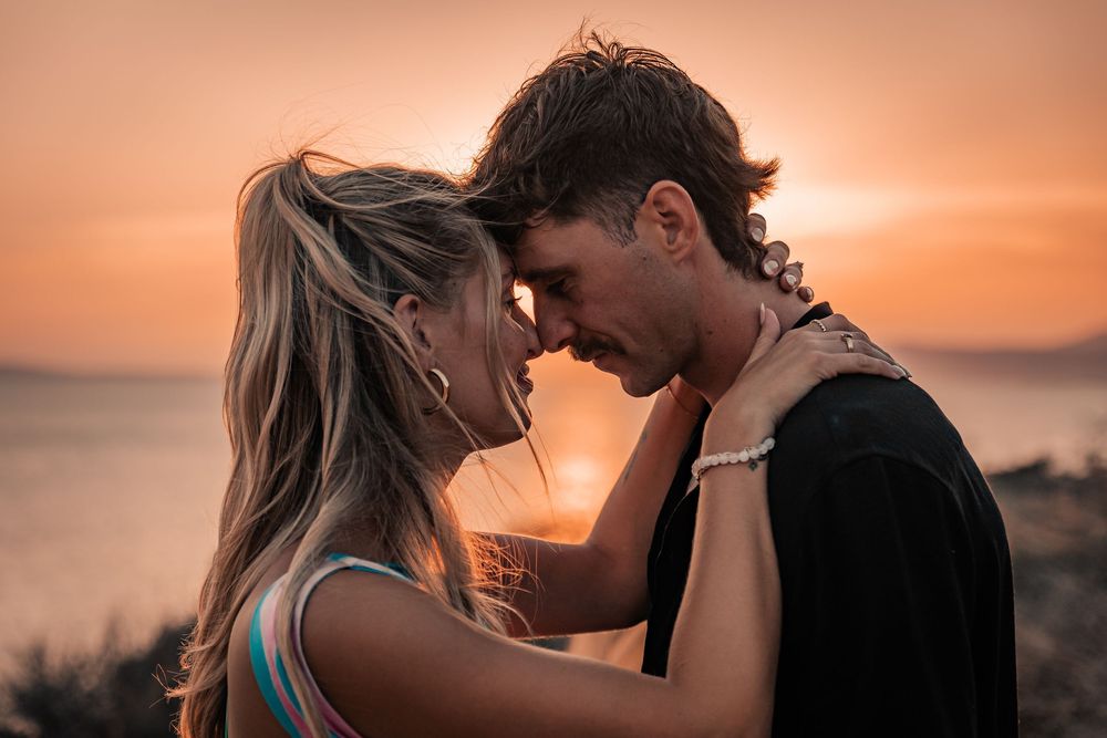 Close-up of a newly engaged couple leaning their foreheads together during a romantic golden hour surprise proposal session in Mallorca.