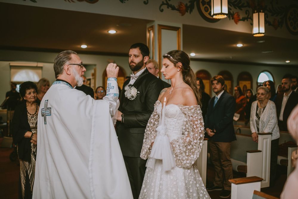 Priest blessing bride and groom during wedding ceremony in a church.