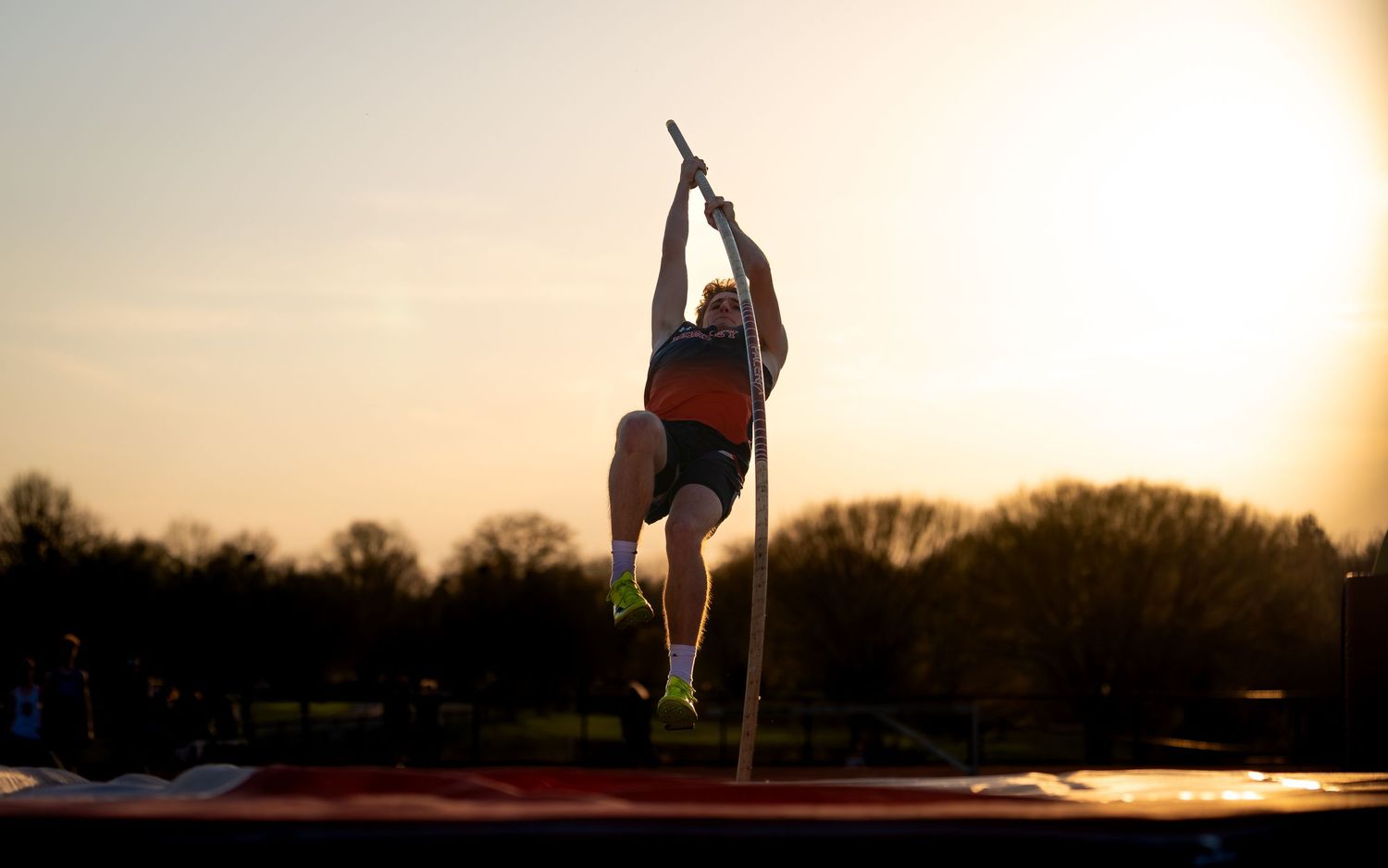 Hershey Trojans pole vaulter clearing the bar at sunset, Meet of Champions, by Deanna Fox, SportsFox Photography, Hershey PA