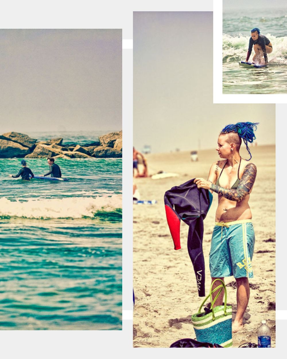 Tattooed woman with blue dreadlocks holding a wetsuit on a sunny beach near the ocean.