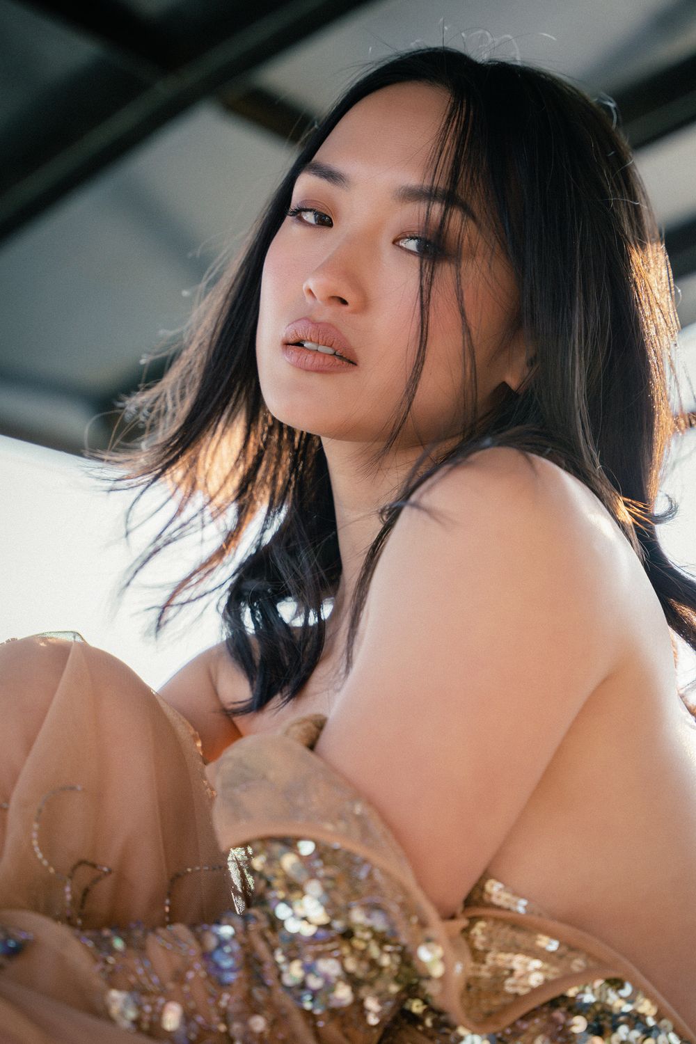 A series of artistic portraits showing a woman with dark hair in a sequined dress against a soft blurred background.