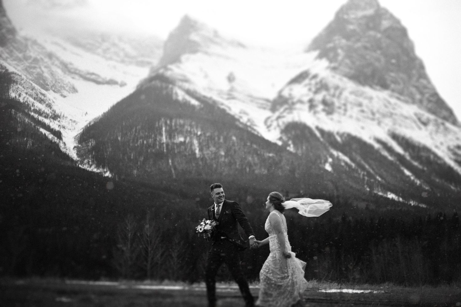 Bride with long veil blowing in the wind against Banff mountain views