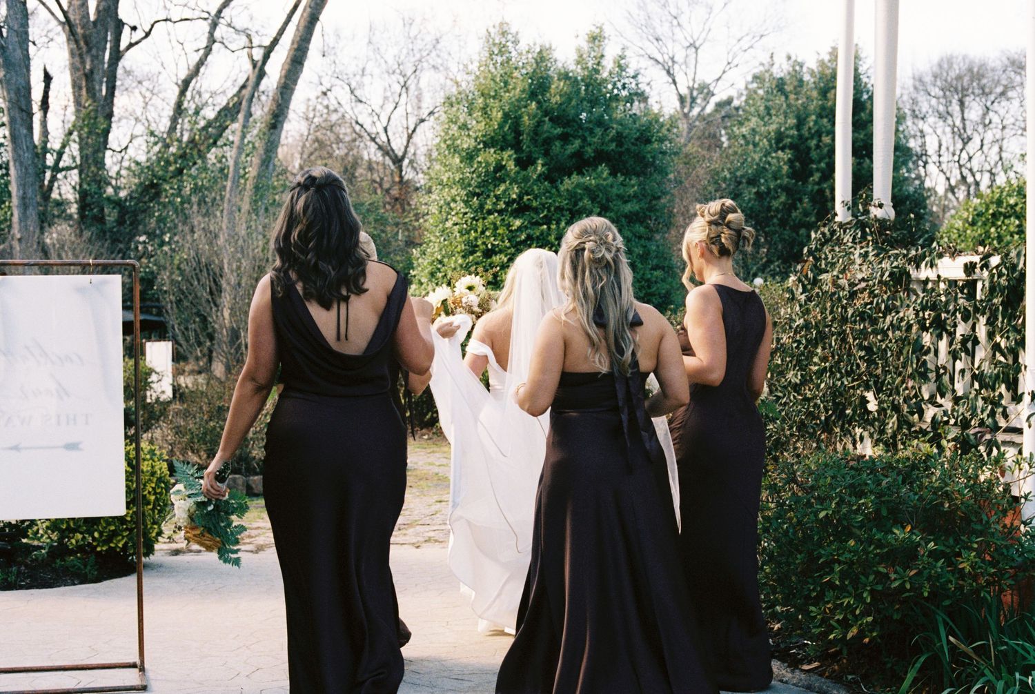 35mm film photography of brides and bridesmaids walking at Georgia wedding venue.
