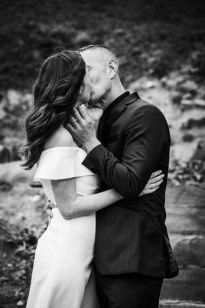A romantic black and white photo series showing a couple sharing intimate kisses in an outdoor setting.