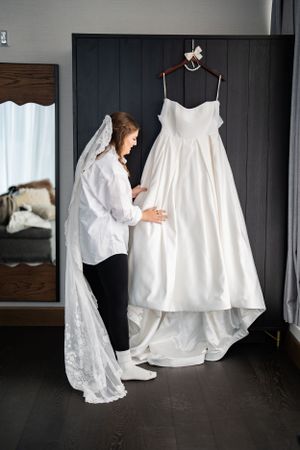 A traditional white wedding dress hangs on display as it is prepared for a special day.
