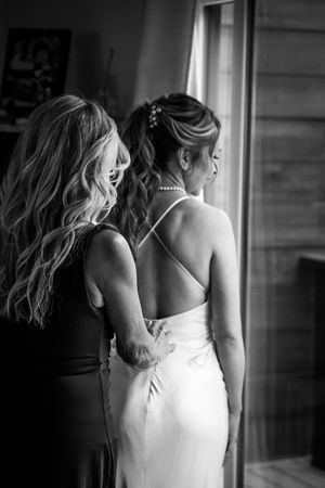 A series of black and white photos showing close-up details of a bride's dress and pearl necklace.