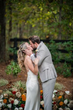 A romantic wedding kiss sequence captured in a garden setting with colorful flowers in the foreground.
