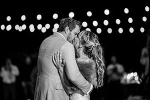 A romantic black and white dance scene with string lights glowing softly in the background.