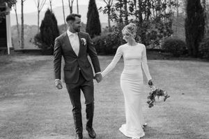 A black and white wedding photo collage showing candid moments of a couple walking and embracing outdoors.