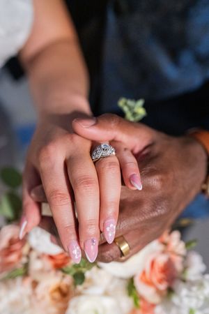 Close-up of hands preparing food with fresh ingredients and garnishes on a light surface.