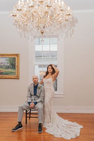 Elegant wedding dress captured in a room with a crystal chandelier and hardwood floors.