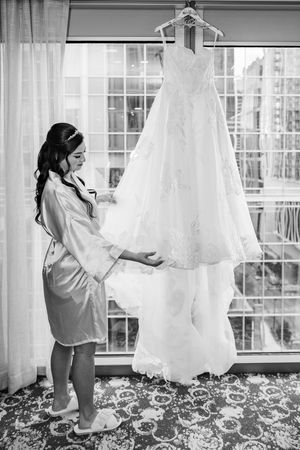 Black and white photo sequence showing someone in a white robe reaching for a wedding dress hanging by a window.