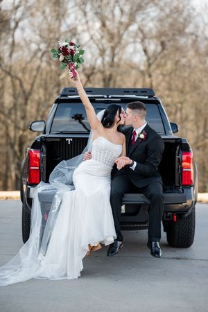 A wedding couple poses playfully near a black pickup truck in a romantic photo sequence.