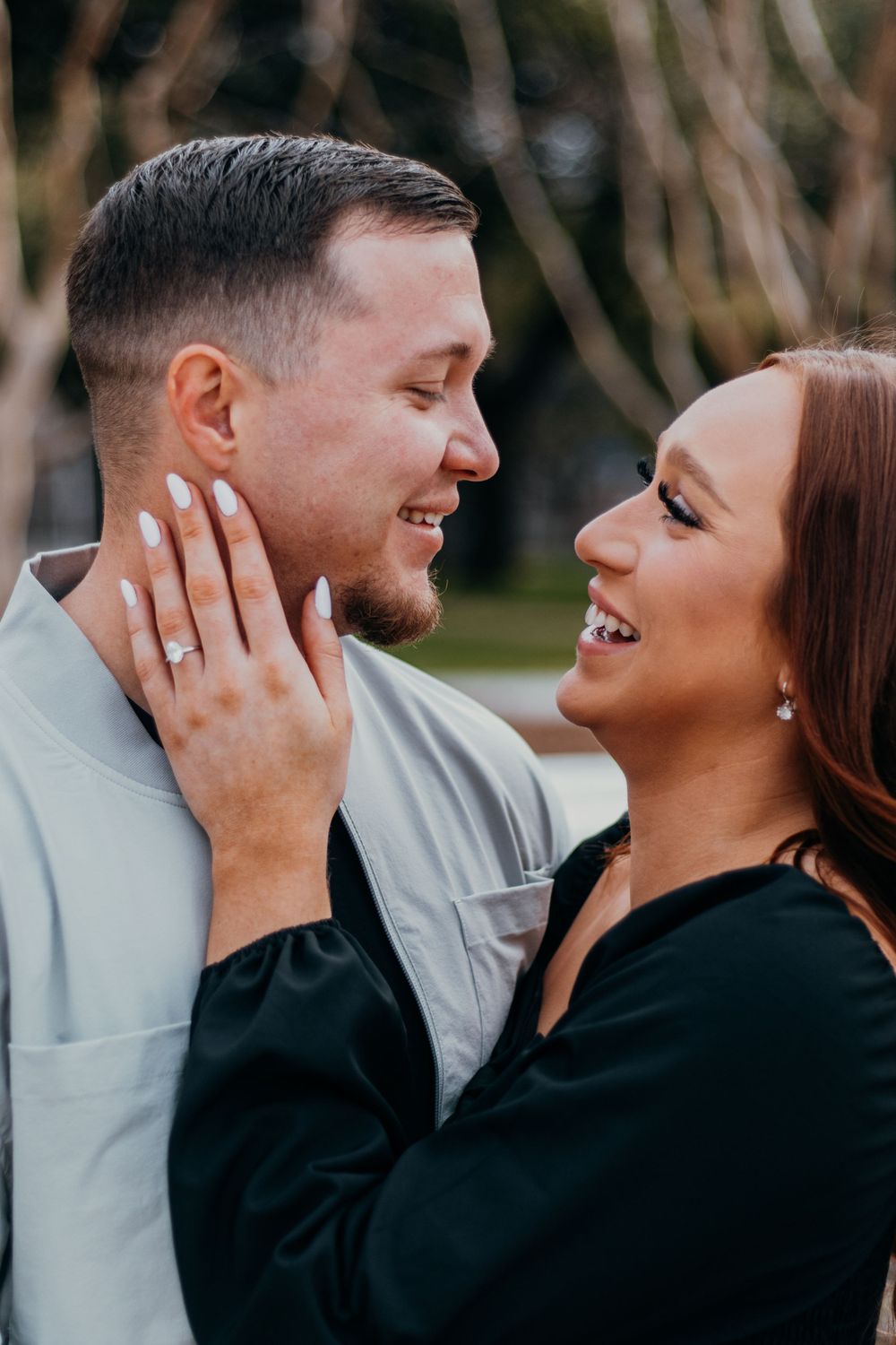 Intimate couple portrait session showing affection against natural outdoor background.